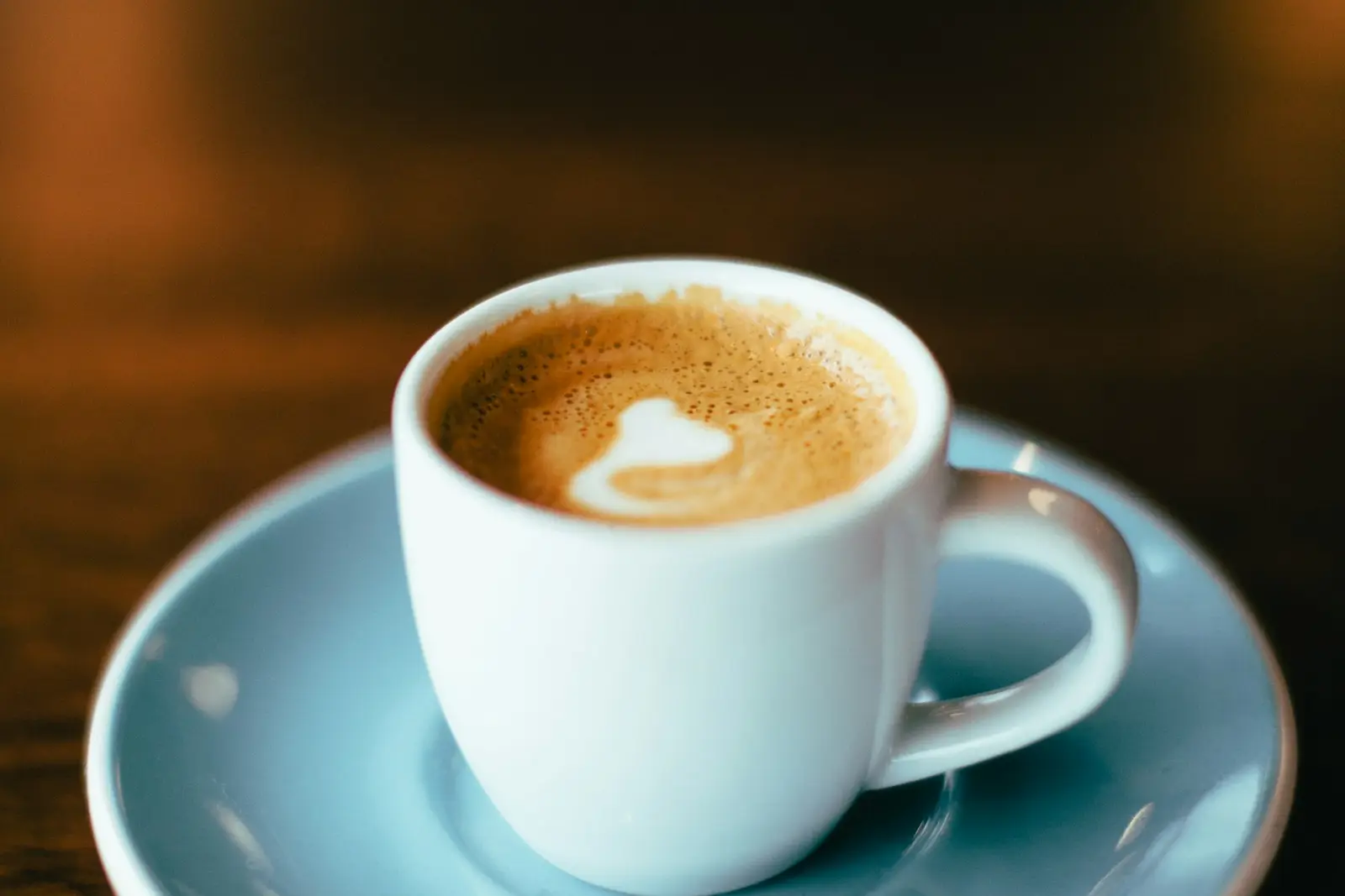 A cappuccino in a pale blue cup and saucer