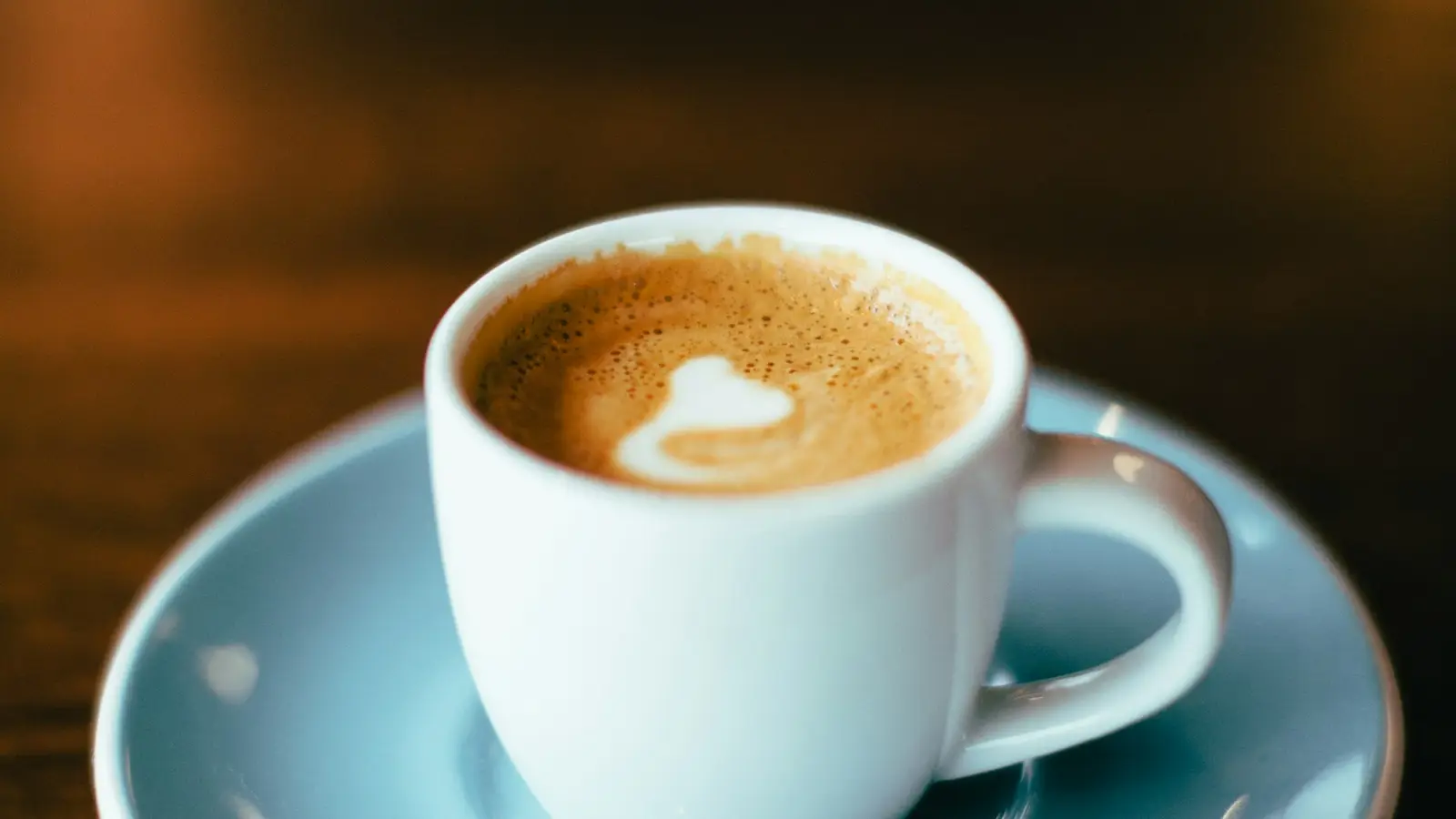 A cappuccino in a pale blue cup and saucer