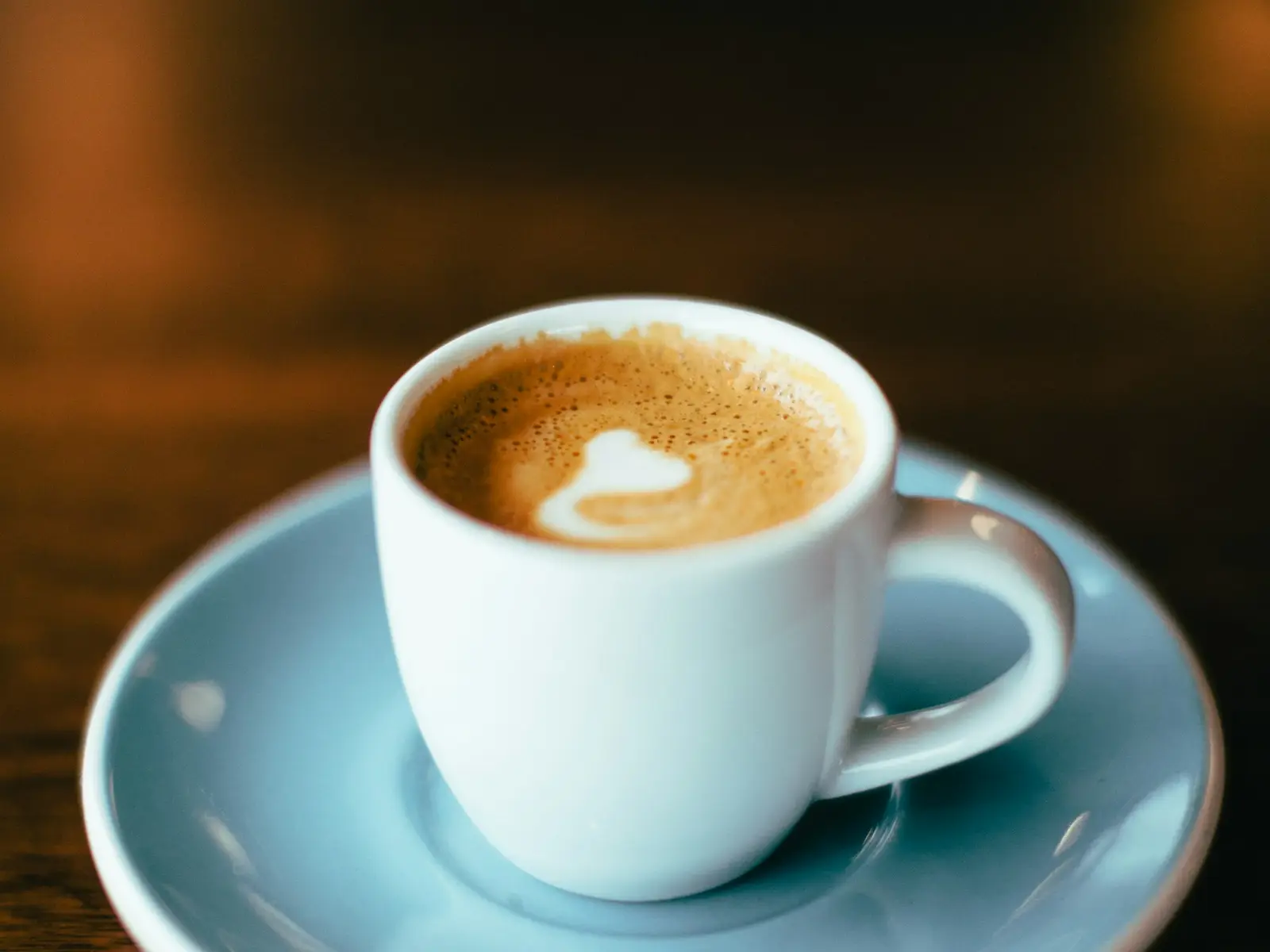 A cappuccino in a pale blue cup and saucer