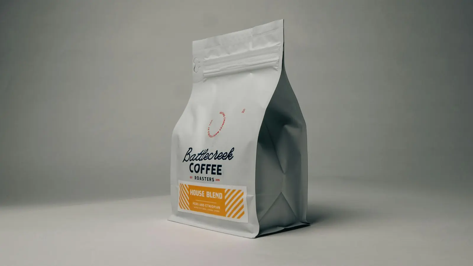 A bag of roasted specialty coffee on a grey table