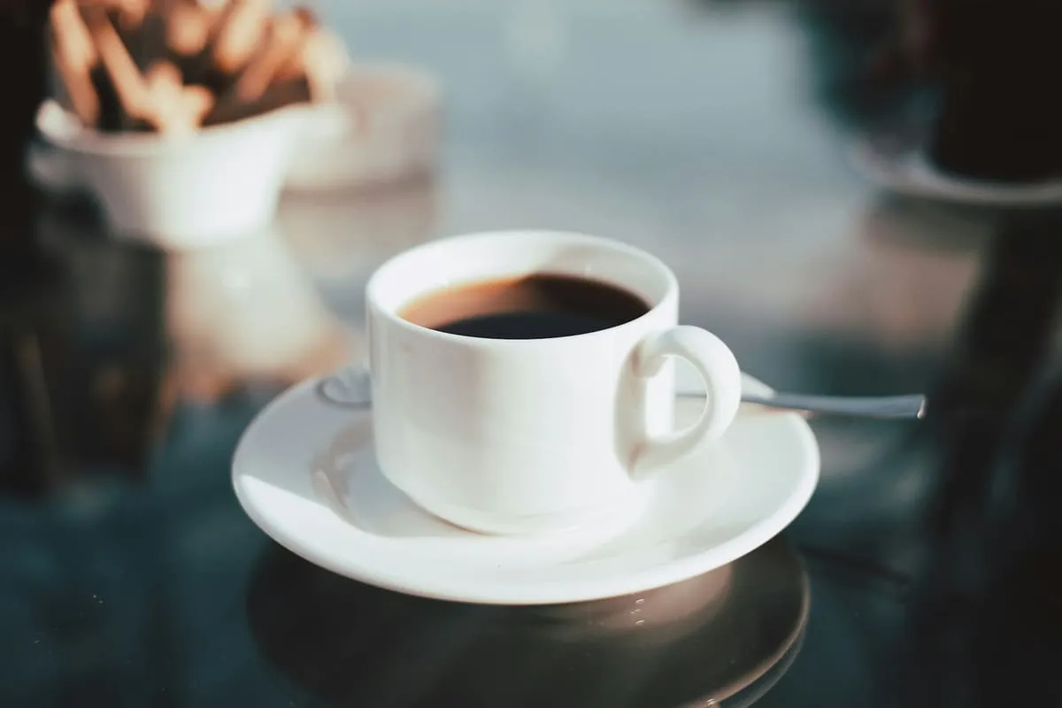 A single cup of black coffee on a saucer